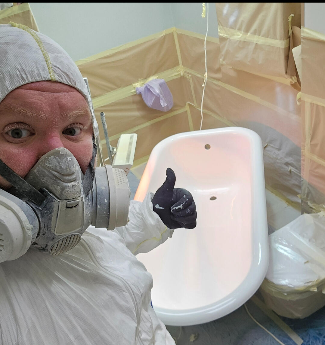 photo of glossy baths owner photo of glossy baths re-enamelling owner Seamus with a thumbs up, in ppe, in a room full of masking up and a completed bath in Portsmouth